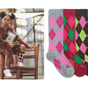 May include: Three pairs of knee-high socks with argyle patterns. The socks are grey with pink diamonds, red with green diamonds, and brown with green diamonds.
