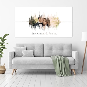 May include: A white canvas print with a sound wave design featuring a photo of a couple. The sound wave is made up of vertical lines in shades of brown and green. The text "Jennifer & Peter" is printed below the sound wave.