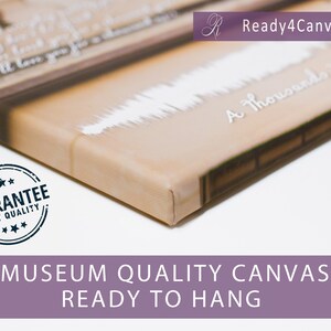 May include: A close-up of a canvas print with a white sound wave design and the text "A Thousand Years". The canvas is wrapped around a wooden frame and has a brown background. The print is labeled "Ready4Canvas" and has a "Guarantee Best Quality" stamp.