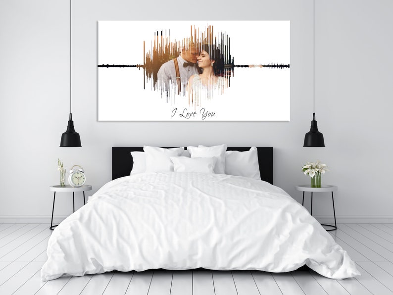 May include: A white canvas print with a black and brown sound wave design. The sound wave is shaped like a heart and includes a photo of a couple. The text "I Love You" is written below the sound wave.