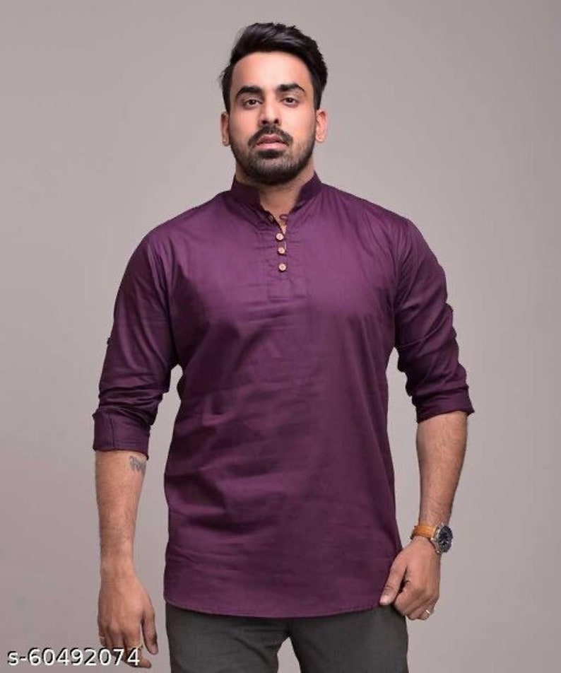 Pu&ograve; includere: Una camicia a maniche lunghe viola scuro con colletto alla coreana e tre bottoni in legno. La camicia &egrave; realizzata in un tessuto a tinta unita e ha una vestibilit&agrave; rilassata. Le maniche sono arrotolate fino ai gomiti.