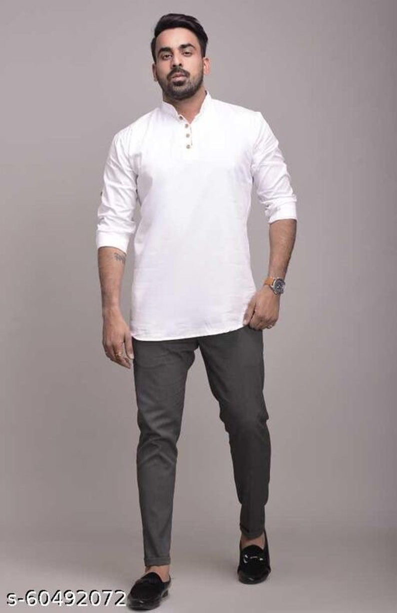 Pu&ograve; includere: Una camicia bianca a maniche lunghe con colletto alla coreana e tre bottoni, abbinata a pantaloni grigio scuro e mocassini neri. La camicia ha una vestibilit&agrave; morbida. I pantaloni sono a taglio slim. Le scarpe sono slip-on.