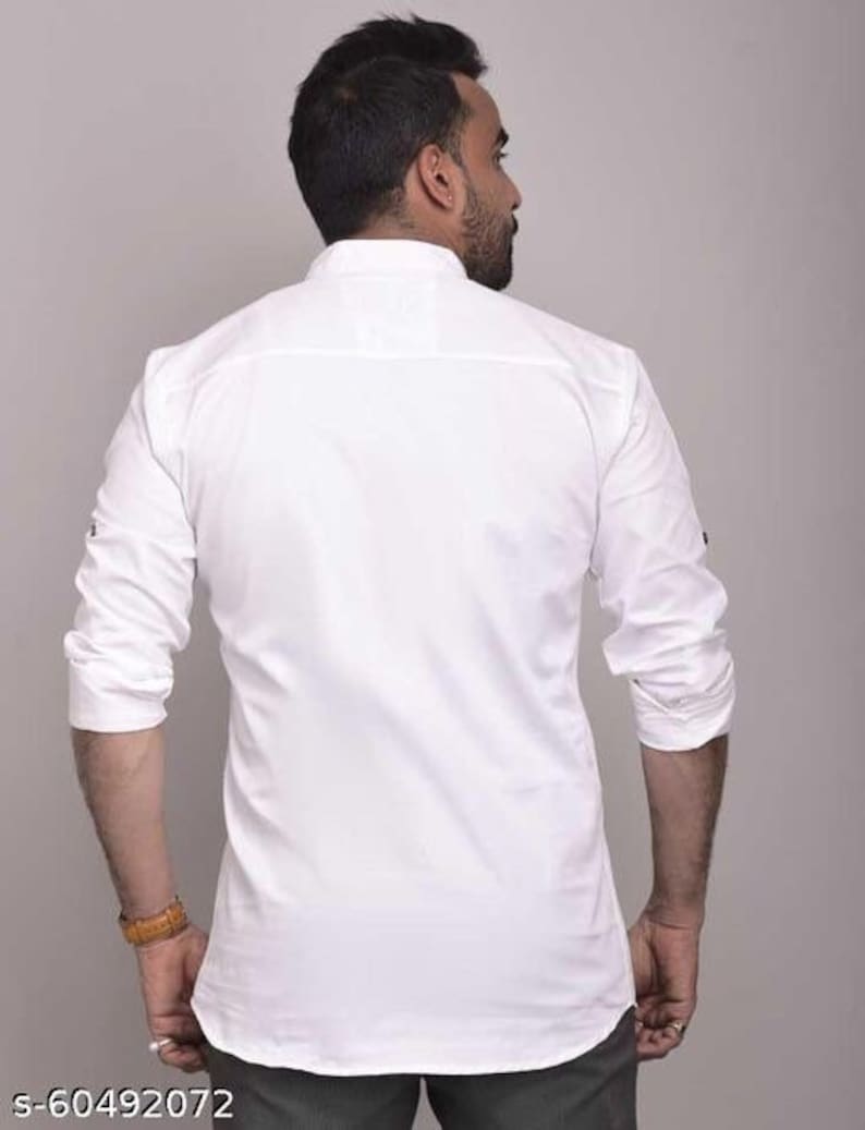 Pu&ograve; includere: Camicia bianca a maniche lunghe con colletto alla coreana. La camicia ha polsini con bottoni e un orlo curvo. La vista posteriore mostra il design e la vestibilit&agrave; della camicia. La camicia &egrave; di colore bianco.