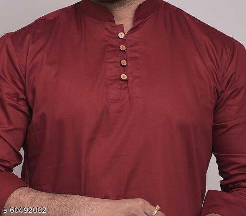Pu&ograve; includere: Una camicia kurta color bordeaux con colletto alla coreana e maniche lunghe. La camicia presenta una paramontura con bottoni con quattro bottoni in legno. Il tessuto sembra essere un materiale morbido e tessuto. Il testo "s-60492082" &egrave; nell'angolo in basso a sinistra.