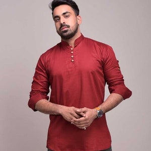 Pu&ograve; includere: Una camicia bordeaux a maniche lunghe con colletto alla coreana e abbottonatura. La camicia ha polsini abbottonati ed &egrave; realizzata in un tessuto liscio. Lo stile &egrave; una camicia casual con bottoni.