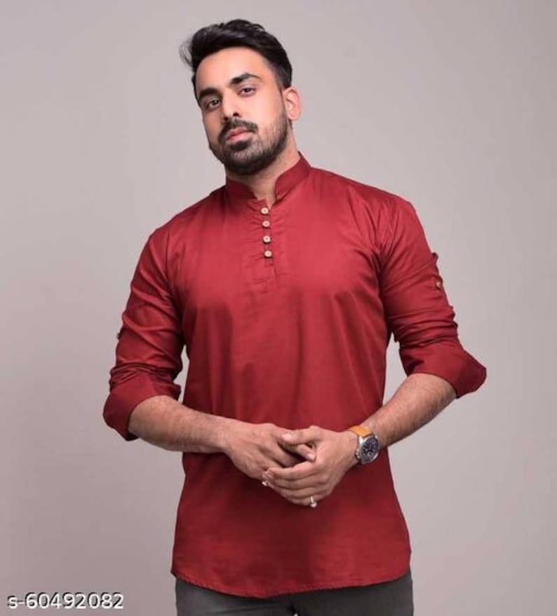 Pu&ograve; includere: Una camicia bordeaux a maniche lunghe con colletto alla coreana e abbottonatura. La camicia ha polsini abbottonati ed &egrave; realizzata in un tessuto liscio. Lo stile &egrave; una camicia casual con bottoni.