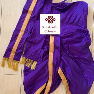 May include: A vibrant purple traditional Indian garment, with gold trim and tassels. The fabric is draped and folded, with a matching sash. The image includes the text "Sanskruthi Ethnics".