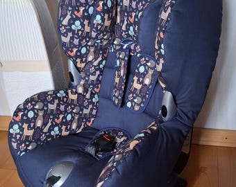 May include: A blue car seat with a woodland animal print fabric cover. The seat has a five-point harness and a headrest.