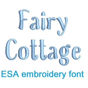 May include: Light blue embroidered text on a white background reads "Fairy Cottage" in a whimsical font. Below the text, in a smaller, darker blue font, it says "ESA embroidery font".