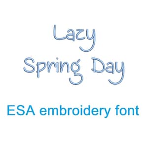 Puede incluir: Un diseño de fuente bordada azul que dice "Lazy Spring Day" en un estilo de escritura caprichoso. El texto "ESA embroidery font" también está incluido en azul.
