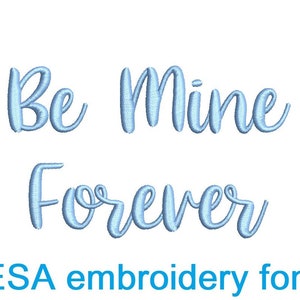 May include: Light blue embroidered text on a white background reads "Be Mine Forever". Below the text is "ESA embroidery font". The script is in a cursive style, perfect for romantic projects.