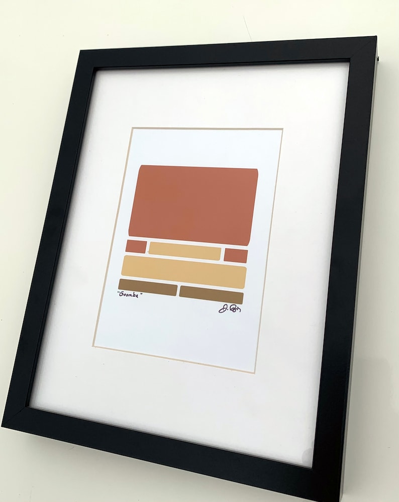 May include: A framed abstract art print with a geometric design in shades of brown, beige, and orange. The print is titled "Sombre" and signed by the artist.