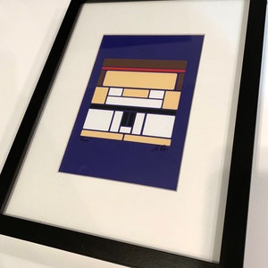 Pode incluir: Uma impress&atilde;o de arte geom&eacute;trica abstrata emoldurada com fundo azul, formas geom&eacute;tricas brancas, amarelas e pretas e acentos vermelhos e marrons. A impress&atilde;o &eacute; assinada "Kya" e "J. Per" nos cantos inferiores.