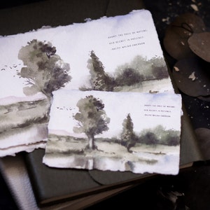 May include: Watercolor landscape art prints featuring a serene scene with trees, a body of water, and a soft, muted color palette. The prints include the quote "Adopt the pace of nature, her secret is patience." by Ralph Waldo Emerson.