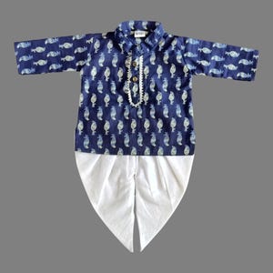 May include: A blue and white patterned kurta with a white dhoti. The kurta has a button closure and a white pearl-like trim. The dhoti is a traditional Indian garment.