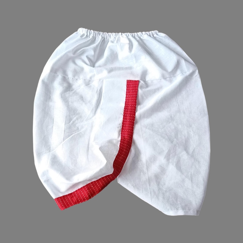 Puede incluir: Pantal&oacute;n blanco de algod&oacute;n con ribete rojo y blanco a rayas alrededor de las piernas.