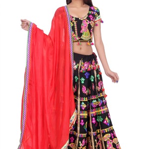 Puede incluir: Un vestido de estilo indio negro y rojo con bordados coloridos y trabajo de espejo. El vestido incluye una falda, una blusa de manga corta y una dupatta roja.