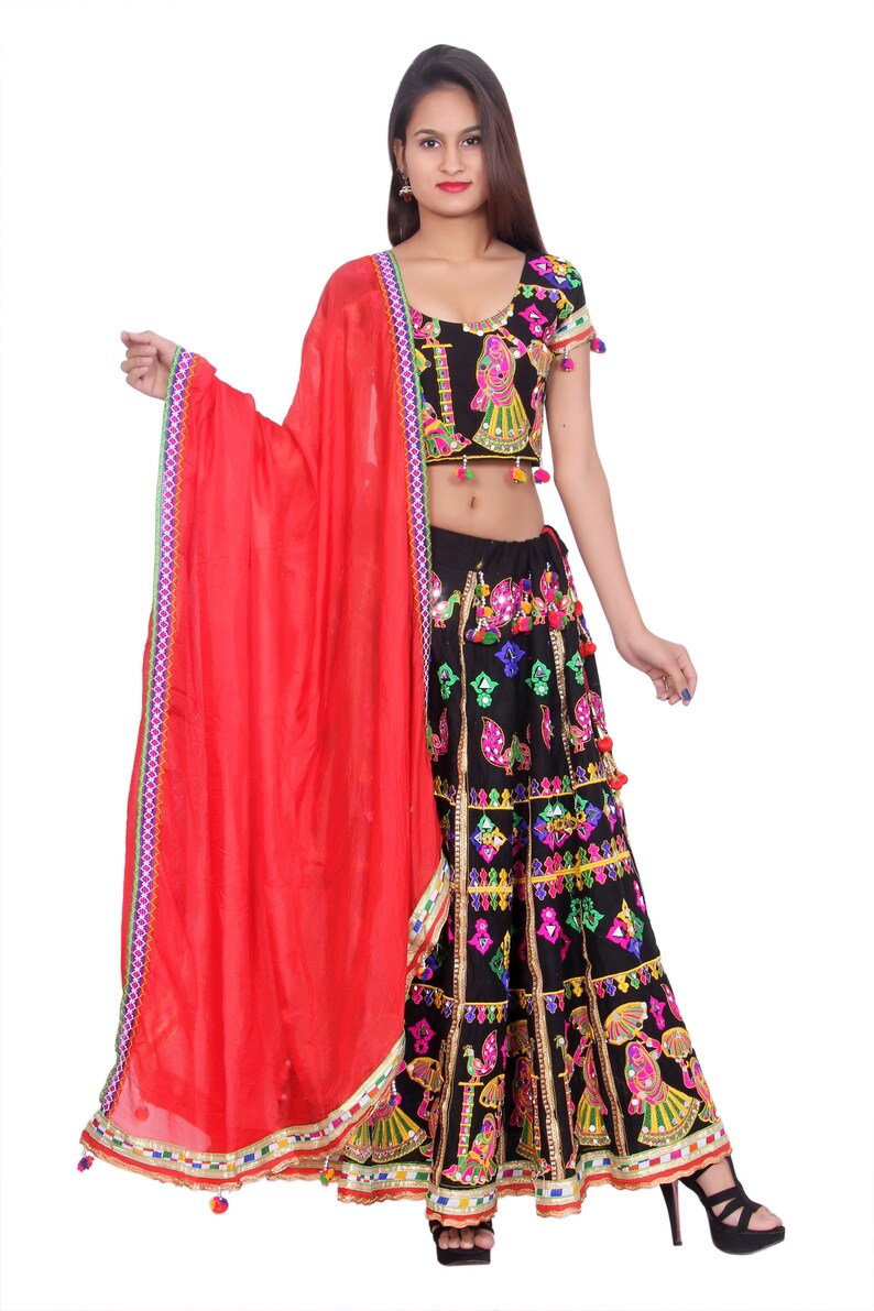 Puede incluir: Un vestido de estilo indio negro y rojo con bordados coloridos y trabajo de espejo. El vestido incluye una falda, una blusa de manga corta y una dupatta roja.