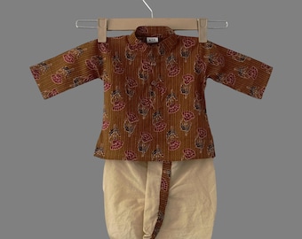 May include: A brown and beige two-piece outfit for a child. The top has a floral print and a mandarin collar. The bottom is a dhoti pant.