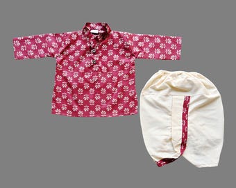 May include: A two-piece outfit for a child, featuring a long-sleeved shirt and matching pants. The shirt is a deep red with a white floral pattern, and the pants are off-white with a red stripe detail. The outfit is designed for comfort and style.