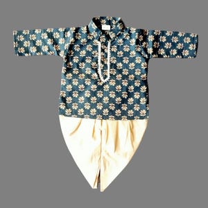 May include: A dark blue and gold patterned kurta with a white trim and a matching cream dhoti. The kurta has a button closure at the neck.