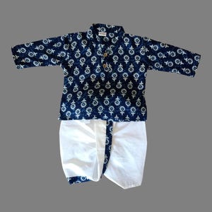 Puede incluir: Un kurta azul y blanco con estampado y un dhoti blanco. El kurta tiene cierre de botón y cuello. El dhoti tiene un ribete azul.