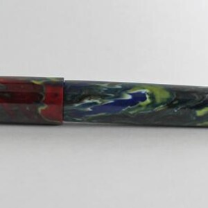 May include: A colorful fountain pen with a red, yellow, blue, and green marbled design.