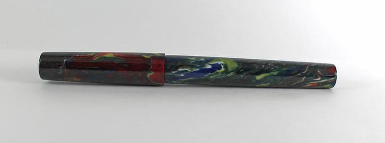 May include: A colorful fountain pen with a red, yellow, blue, and green marbled design.