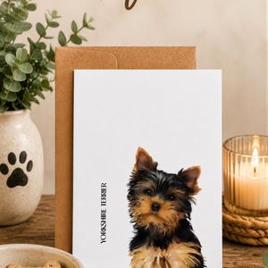 a cozy scene with a dog, a card, and various items such as a bowl, a candle, and a plant. The text "Dog Lover Gifts" is displayed above the card, which has a picture of a dog on it.