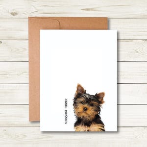 A white card with a brown envelope is placed on a wooden surface.