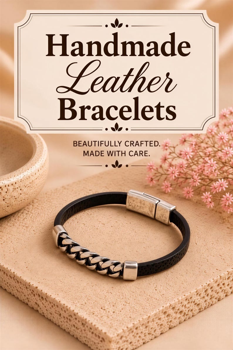 a black leather bracelet with silver metal accents, placed on a beige surface. The background includes a small floral arrangement and a beige bowl.