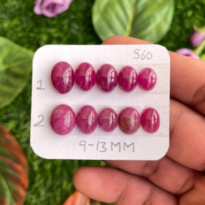 May include: A card with two rows of oval-shaped ruby gemstones, each row labelled with the number "1" and "2". The card also includes the text "S60" and "9-13 MM".