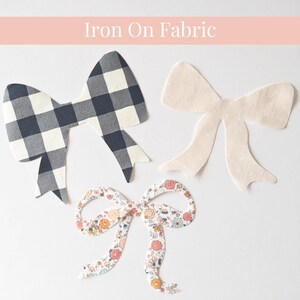 Puede incluir: Tres lazos de tela con diferentes diseños. Uno tiene un patrón de cuadros blancos y negros, otro es de color crema liso y el tercero presenta un estampado floral con flores rosas, naranjas y azules. El texto "Iron On Fabric" está en la parte superior.