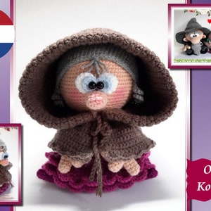 Puede incluir: Muñeca de ganchillo hecha a mano con una capa con capucha marrón y un vestido rosa y morado. La muñeca tiene una cara redonda con ojos azules grandes y una pequeña nariz rosa. La muñeca mide unos 15 cm de altura.