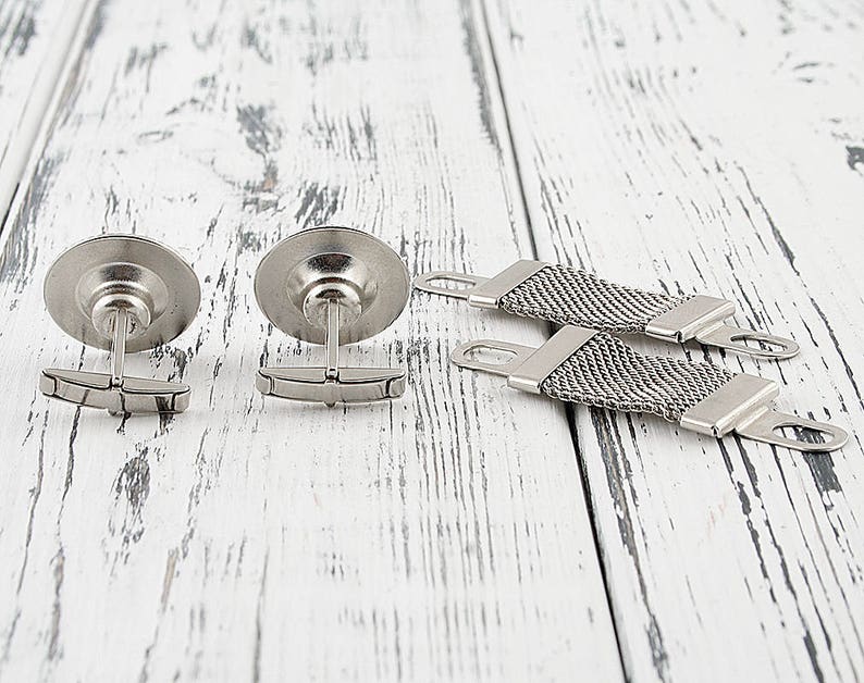 May include: Two silver cufflinks with a round, textured design and a silver chain with a textured design.