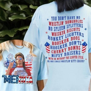 Peut inclure: T-shirts bleu clair avec des motifs patriotiques. L'un des t-shirts présente un homme avec des lunettes de soleil et le mot "'MERICA" en rouge, blanc et bleu. L'autre t-shirt contient du texte sur les feux d'artifice.