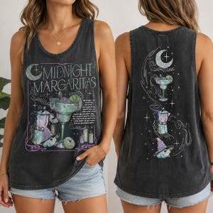 Könnte beinhalten: Ein ärmelloses Tanktop in Anthrazit mit einem Grafikdruck und dem Text "MIDNIGHT MARGARITAS". Das Design zeigt ein Margaritaglas, eine Mokkakanne, einen Frosch mit Hexenhut, Kerzen sowie eine Mondsichel mit Sternen.