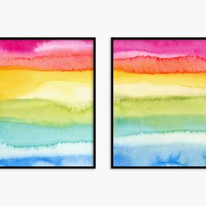 May include: Two framed watercolour paintings with a rainbow colour scheme. The paintings feature horizontal stripes of pink, orange, yellow, green, blue, and light blue.