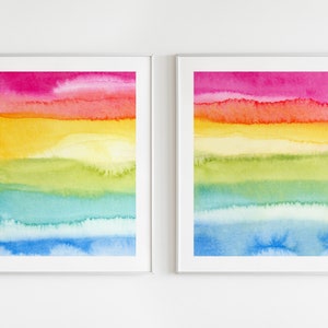 May include: Two framed watercolour paintings with a rainbow colour scheme. The paintings feature horizontal stripes of pink, orange, yellow, green, blue, and light blue.