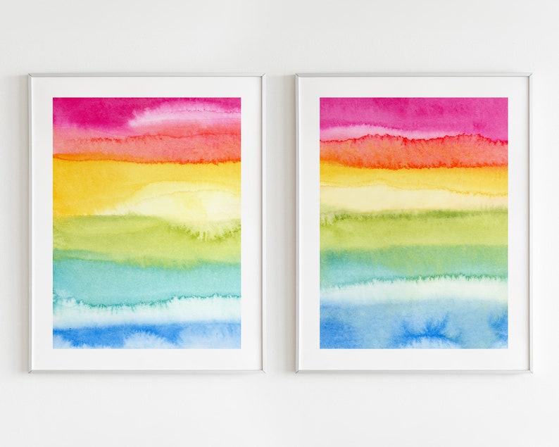 May include: Two framed watercolour paintings with a rainbow colour scheme. The paintings feature horizontal stripes of pink, orange, yellow, green, blue, and light blue.