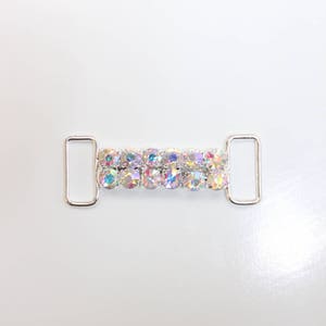 May include: Silver metal slider with two rows of iridescent rhinestones.