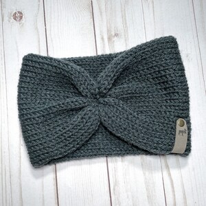 Peut inclure: Un bandeau en tricot gris avec une &eacute;tiquette en cuir marron orn&eacute;e d'un logo de  moose blanc.