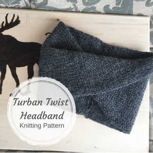 May include: A gray knitted turban twist headband. The headband is on a light wood surface with a black silhouette of a moose in the background. The text "Turban Twist Headband Knitting Pattern" is written in a white circle.