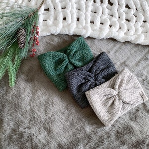 Peut inclure: Trois bandeaux en tricot de couleur verte, grise et beige avec un n&oelig;ud nou&eacute;. Les bandeaux sont dispos&eacute;s sur une surface grise et duveteuse.