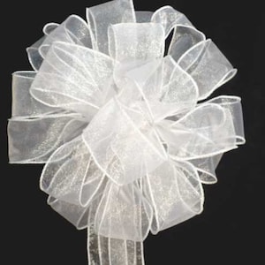 May include: A white sheer ribbon bow with a shimmery finish. The bow is tied with a single loop and has a long tail.