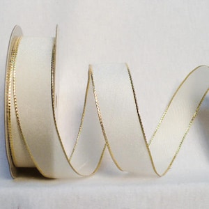 May include: White satin ribbon with a gold edge. The ribbon is curled and twisted, showing off the gold trim.
