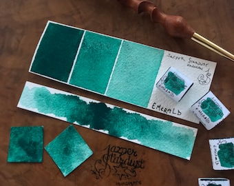 May include: A watercolor paint swatch in shades of green, labeled "Emerald" with the brand name "Jazper Stardust Handmade".