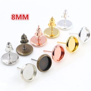 May include: Eight 8mm round earring settings in various metal finishes: silver, gold, bronze, rose gold. Each setting has a flat back and a post for attaching to an earring.