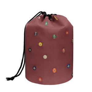 May include: A maroon drawstring bag featuring a pattern of colorful billiard balls. The balls are numbered and scattered across the bag's surface. The bag has a black drawstring closure.