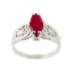 Puede incluir: Un anillo de plata con una piedra preciosa roja en forma de marquesa engastada en un diseño de filigrana.